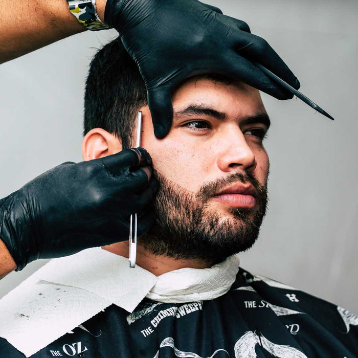 Hair Stylist Wearing Black Nitrile Gloves While Trimming Client Facial Hair 