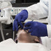 Dental Technician in Indigo Nitrile Gloves Examining Patient Mouth 