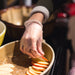 Baker in Clear Industrial Vinyl Gloves Layering Apples on Cake Batter 