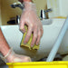 Clear Industrial Vinyl Glove on Hand Cleaning Bathroom with Yellow Sponge 